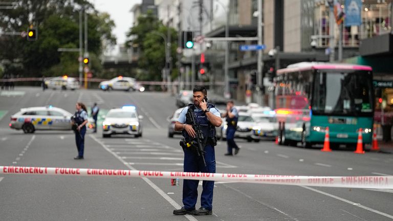 Armed New Zealand police officers stand at a road block in the central business district following a shooting in Auckland, New Zealand, Thursday, July 20, 2023. New Zealand police are responding to reports that a gunman has fired shots in a building in downtown Auckland. (AP Photo/Abbie Parr)