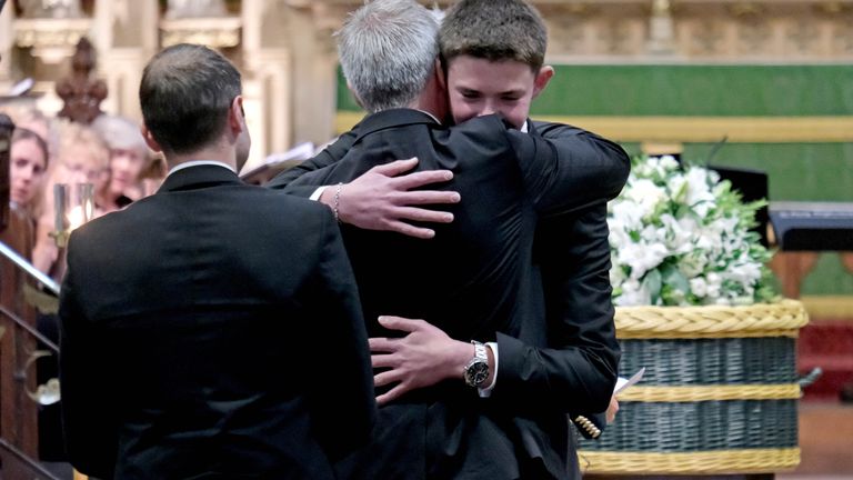 Charlie Webber, the brother of Barnaby Webber, is embraced by their father David Webber during his funeral  
