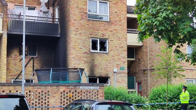 A police officer outside the burned-out flat in Cambridge. Pic: Rex