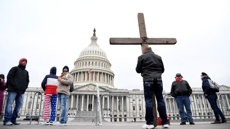 Jeremy LaPointe of Lumberton, Texas, holds a cross as he joins supporters of U.S. President Donald Trump gathered outside the U.S. Capitol where Congress will meet to certify the electoral college vote for President-elect Joe Biden, in Washington, U.S., January 6, 2021. REUTERS/Mike Theiler
