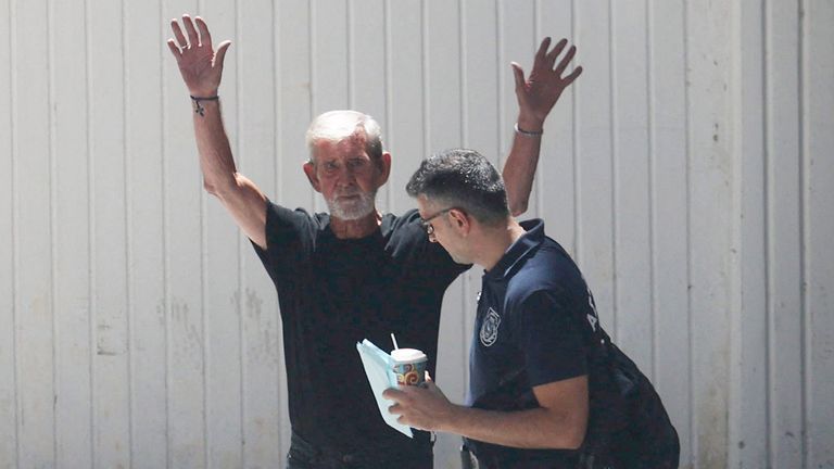 British pensioner David Hunter waves to journalists while being escorted to a police van outside a courthouse in Paphos, Cyprus July 21, 2023. REUTERS/Yiannis Kourtoglou