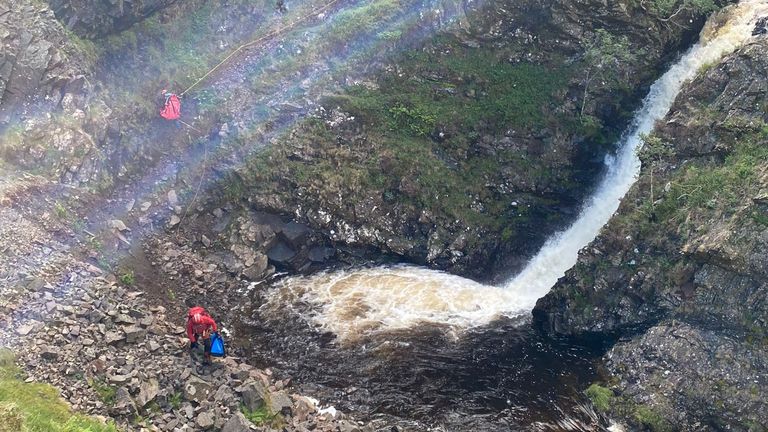 Handout photo issued by the Moffat Mountain Rescue Team of team members rescuing a Jack Russell dog after it plunged 60 metres down the Grey Mare&#39;s Tail waterfall in Dumfries and Galloway at around 2.45pm on Sunday. Picture date: Sunday July 16, 2023.
