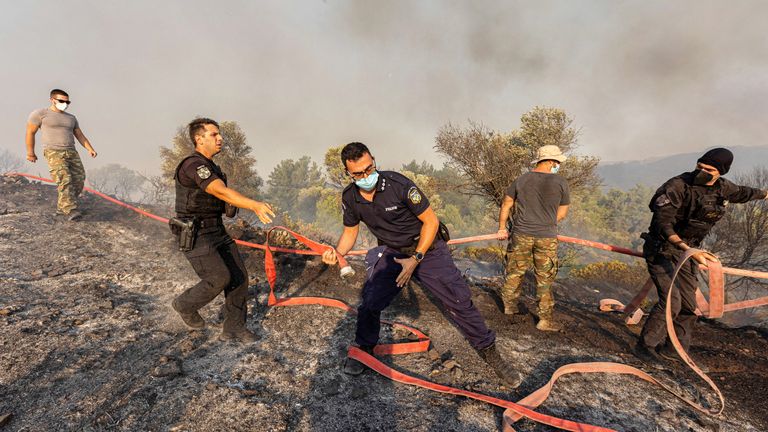 Firefighters, volunteers and police officers operate as a wildfire burns near the village of Asklipieio, on the island of Rhodes, Greece, July 24, 2023. REUTERS/Nicolas Economou