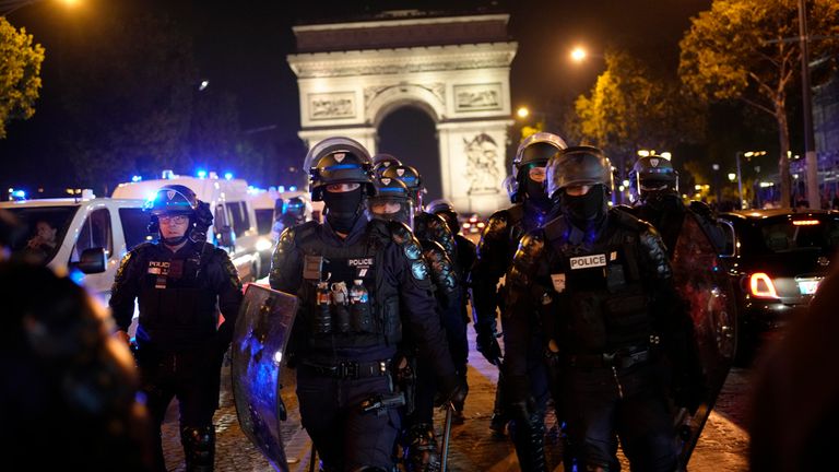 Police officers patrol in front of the Arc de Triomphe on the Champs Elysees in Paris, Saturday, July 1, 2023.