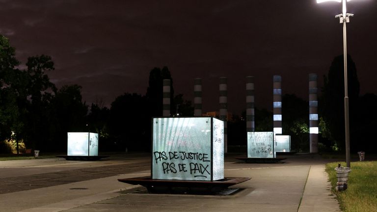 A phrase that reads "No Justice, No Peace" is painted on a crystal cube, in Nanterre