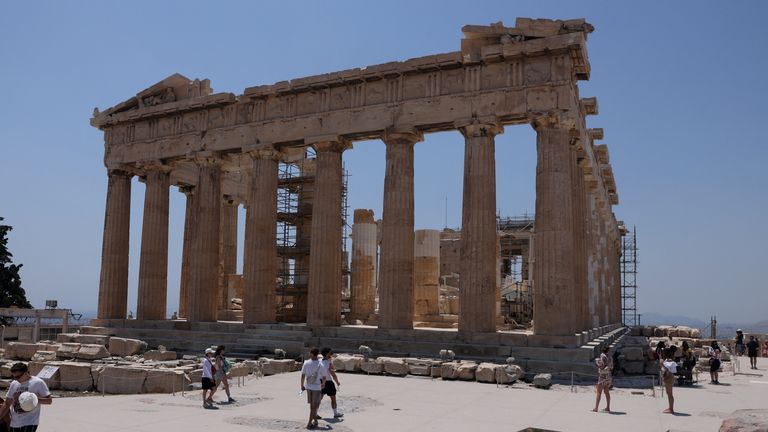 Visitors walk near the Parthenon temple, which sits atop Acropolis hill, during a heatwave in Athens, Greece, July 13, 2023. REUTERS/Louiza Vradi
