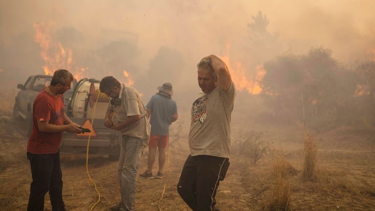 Locals try to extinguish a wildfire burning in Gennadi village, on the Aegean Sea island of Rhodes, Greece  
Pic:AP