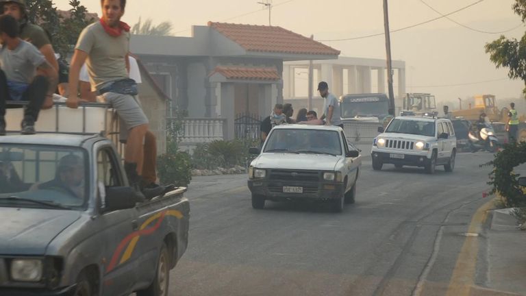 Villagers evacuate from the Greek village of Massari, on the east coast of Rhodes, as wildfires sweep in.