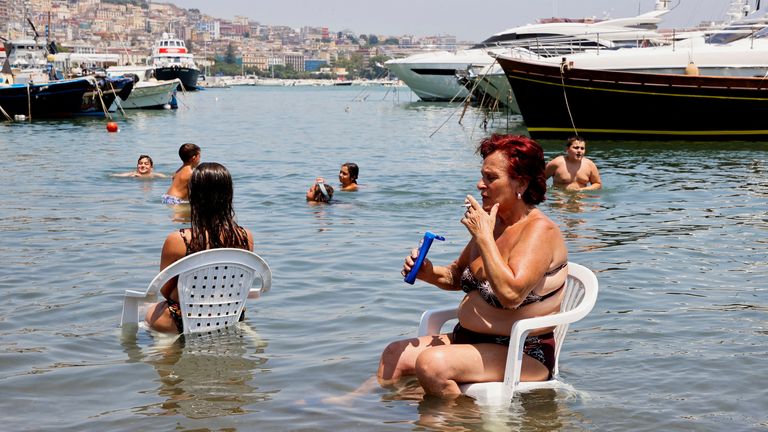 A woman cools off as she sits in the sea during a heatwave across Italy, in Naples, Italy July 10, 2023. REUTERS/Ciro De Luca TPX IMAGES OF THE DAY

