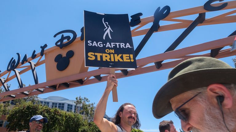 Striking writers and actors walk with pickets outside The Walt Disney Company studio in Burbank, California on Friday, July 14, 2023. (Ringo Chiu via AP)