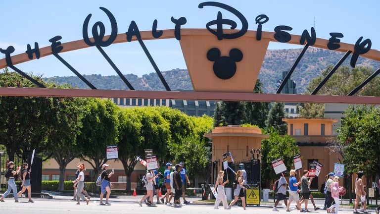 Striking writers and actors walk with pickets outside The Walt Disney Company studio in Burbank, California on Friday, July 14, 2023. (Ringo Chiu via AP)