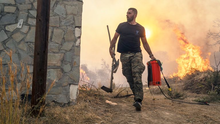 Ilias Kyriakou, 25, runs to extinguish a wildfire burning in Gennadi village, on the Aegean Sea island of Rhodes, Greece
Pic:AP