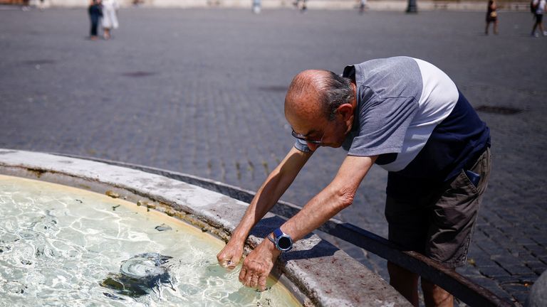 Alfonso  cools off at a fountain at Piazza del Popolo, during a heatwave across Italy, in Rome, Italy