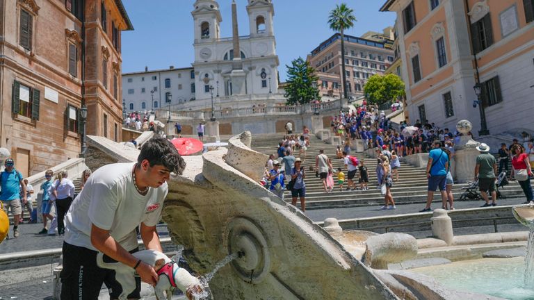 A dog is refreshed by his owner at the Barcaccia fountain of Rome&#39;s Spanish Steps, Monday, July 10, 2023. An intense heat wave has reached Italy, bringing temperatures close to 40 degrees Celsius in many cities across the country. (AP Photo/Gregorio Borgia)