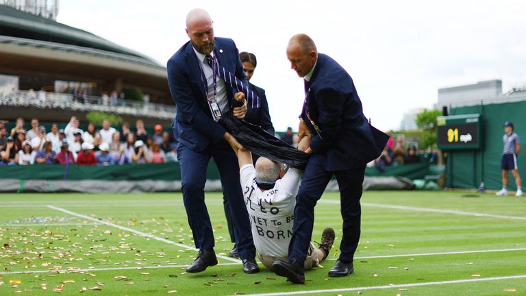 A Just Stop Oil protester is detained by security staff on court 18 during the first round match between Britain&#39;s Katie Boulter and Australia&#39;s Daria Saville  