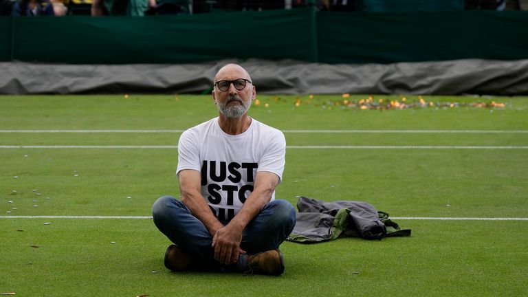 A Just Stop Oil protester sits on Court 18. Pic: AP