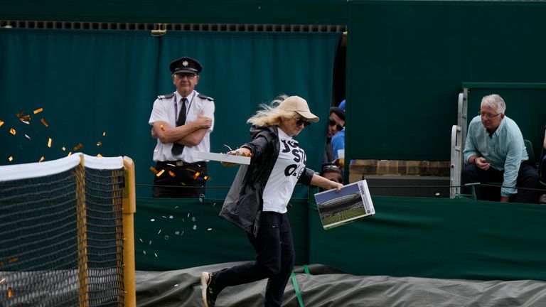 A Just Stop Oil protester runs onto Court 18 and releases confetti on day three of the Wimbledon tennis championships in London, Wednesday, July 5, 2023. (AP Photo/Alastair Grant)