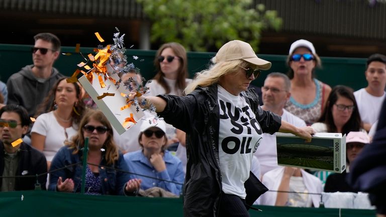 A Just Stop Oil protester runs onto Court 18 and releases confetti on day three of the Wimbledon tennis championships in London, Wednesday, July 5, 2023. (AP Photo/Alastair Grant)