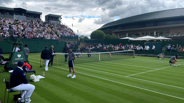 Ground staff clear orange confetti from court 18, two Just Stop Oil protesters ran on to the grass on day three of the 2023 Wimbledon Championships at the All England Lawn Tennis and Croquet Club in Wimbledon.