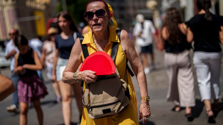 A woman fans herself in Madrid, Spain, Monday, July 10, 2023. Temperatures are beginning to rise at the start of the second heatwave registered in Spain this summer. (AP Photo/Manu Fernandez)