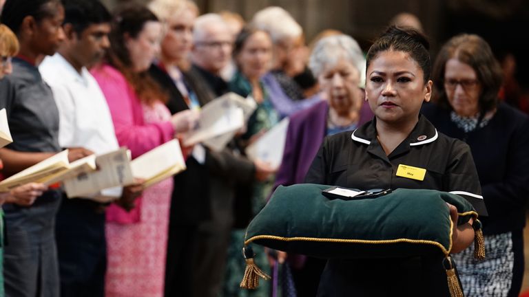 Nurse May Parsons in the procession at the start of the service, carrying the George Cross which the late Queen Elizabeth II awarded to the NHS for services to Covid, at the NHS anniversary ceremony at Westminster Abbey, London, as part of the health service&#39;s 75th anniversary celebrations. Picture date: Wednesday July 5, 2023.