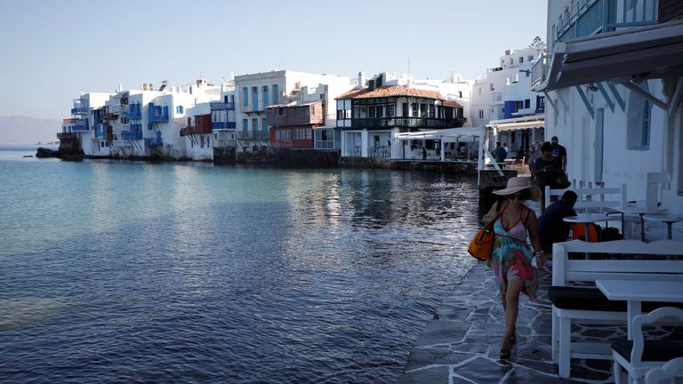 A woman makes her way in Little Venice as Greece banned music in restaurants and bars and imposed a nighttime curfew on the island of Mykonos, Greece, July 18, 2021. REUTERS/Louiza Vradi