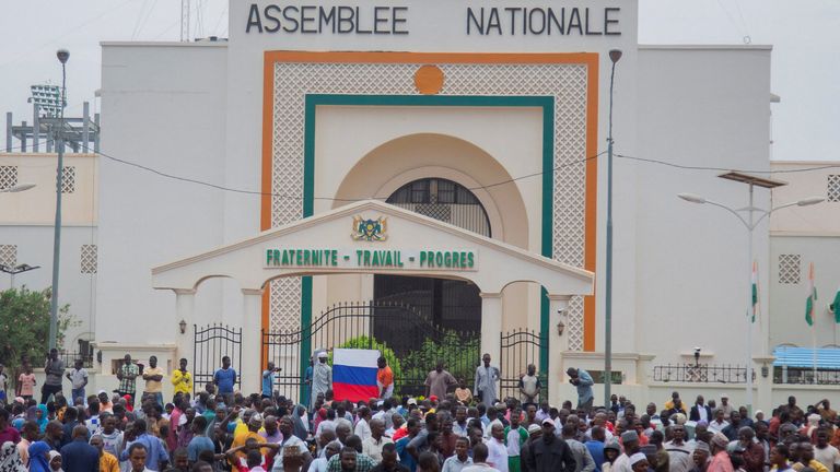 Hundreds of supporters of the coup gather and hold a Russian flag in front of the National Assembly in the capital Niamey, Niger July 27, 2023. REUTERS/Souleymane Ag Anara
