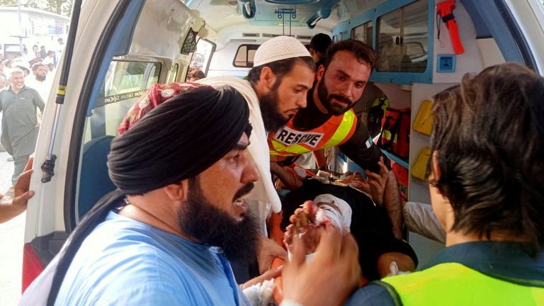 Rescue workers and other people transport an injured person to the hospital, after a blast in Bajaur district of Khyber Pakhtunkhwa, Pakistan July 30, 2023. Rescue 1122/Handout via REUTERS ATTENTION EDITORS - THIS IMAGE HAS BEEN SUPPLIED BY A THIRD PARTY. MANDATORY CREDIT. NO RESALES. NO ARCHIVES