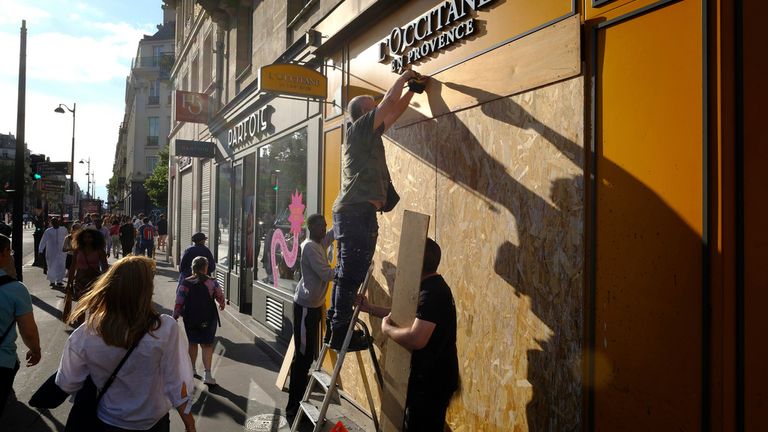 Windows of shops were covered with boards in Paris after disorder broke out last week