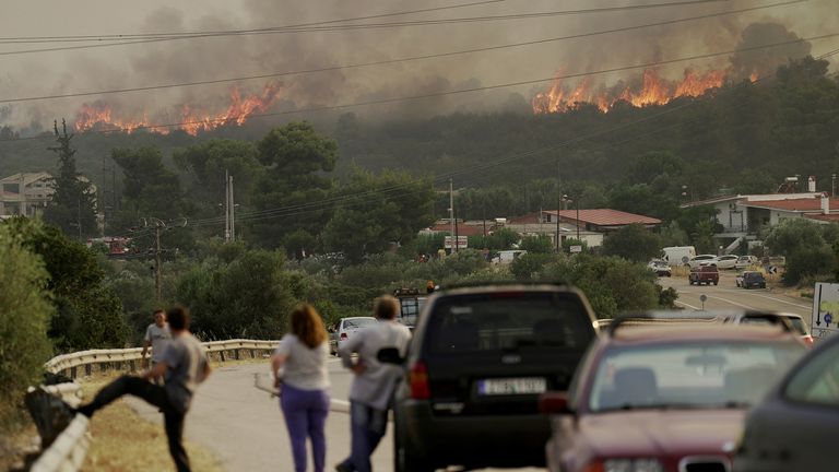 People gather as wildfire burns near the village of Agios Sotira, west of Athens, Greece, July 20, 2023. REUTERS/Fedja Grulovic
