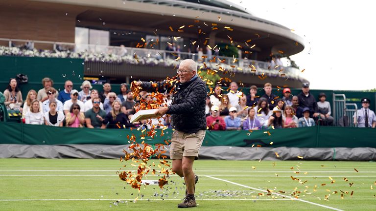 A protester on court 18 throwing confetti on to the grass during Katie Boulter’s first-round match against Daria Saville on day three of the 2023 Wimbledon Championships at the All England Lawn Tennis and Croquet Club in Wimbledon. Picture date: Wednesday July 5, 2023.