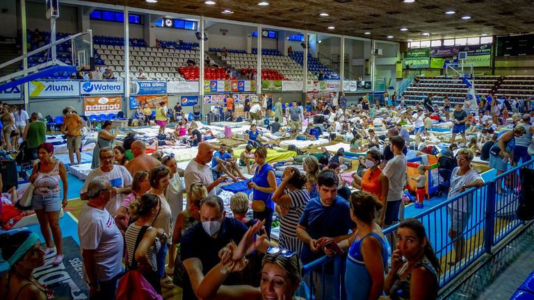 Tourists are sheltered in a sports hall after being evacuated