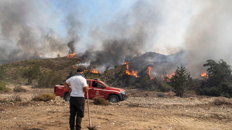 A man watches the fire burning a forest in Vati village, on the Aegean Sea island of Rhodes 
Pic:AP