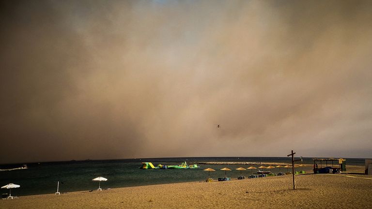 Rodos adasında bir orman yangını sırasında dumanla kaplı bir plaj