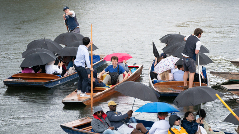 People shelter from the rain under umbrellas as they punt along the River Cam in Cambridge. Picture date: Saturday July 15, 2023.