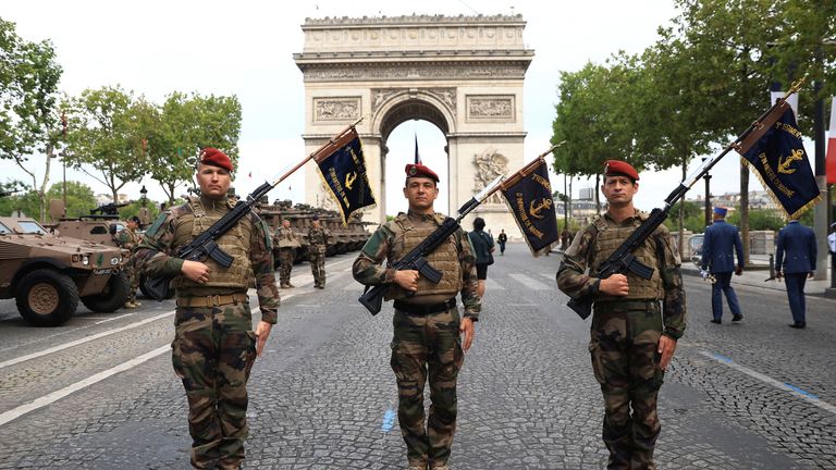 Servicemen of the Navy Infantry pose on the Champs-Elysees avenue in front of the Arc de Triomphe before the Bastille Day military parade Friday, July 14, 2023 in Paris, France. Aurelien Morissard/Pool via REUTERS
