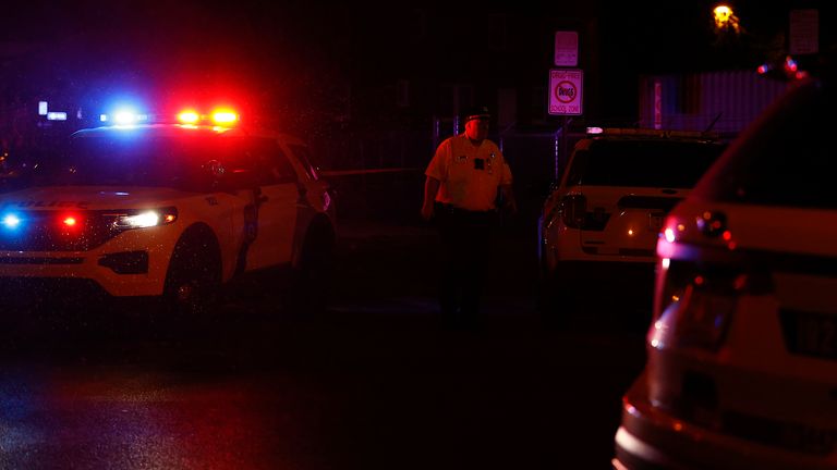 A Philadelphia police officer stands guard at the intersection of 56th Street and Kingsessing Avenue after multiple people were shot in Southwest Philadelphia, late Monday, July 3, 2023. (Yong Kim/The Philadelphia Inquirer via AP)