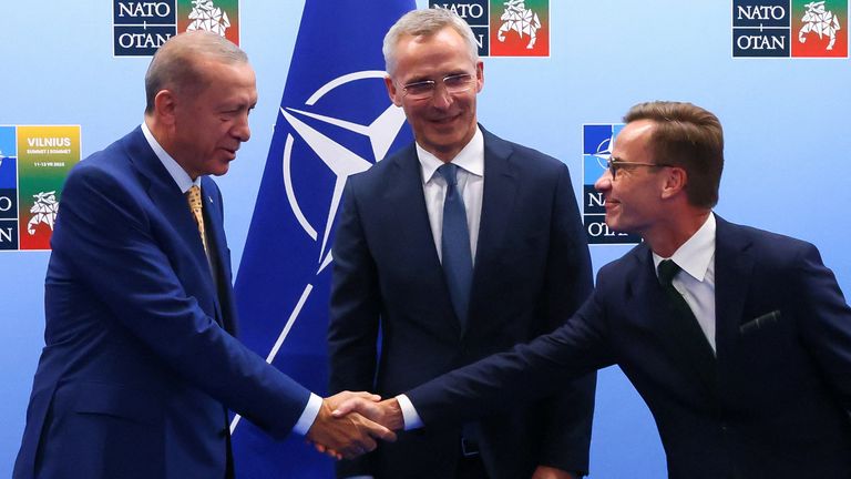 Turkish President Tayyip Erdogan and Swedish Prime Minister Ulf Kristersson shake hands alongside NATO Secretary-General Jens Stoltenberg