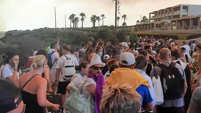 Tourists are being evacuated during a forest fire on the island of Rhodes, Greece, Saturday, July 22, 2023. A large blaze burning on the Greek island of Rhodes for the fifth day has forced authorities to order an evacuation of four locations, including two seaside resorts. (Rhodes.Rodos via AP)
