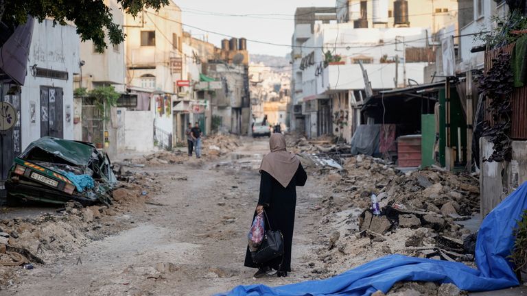 A Palestinian woman walks on a damaged road in the Jenin refugee camp in the West Bank 
Pic:AP
