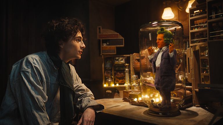 (L-r) TIMOTHÉE CHALAMET as Willy Wonka and HUGH GRANT as an Oompa Loompa in Warner Bros. Pictures and Village Roadshow Pictures’ “WONKA,” a Warner Bros. Pictures release