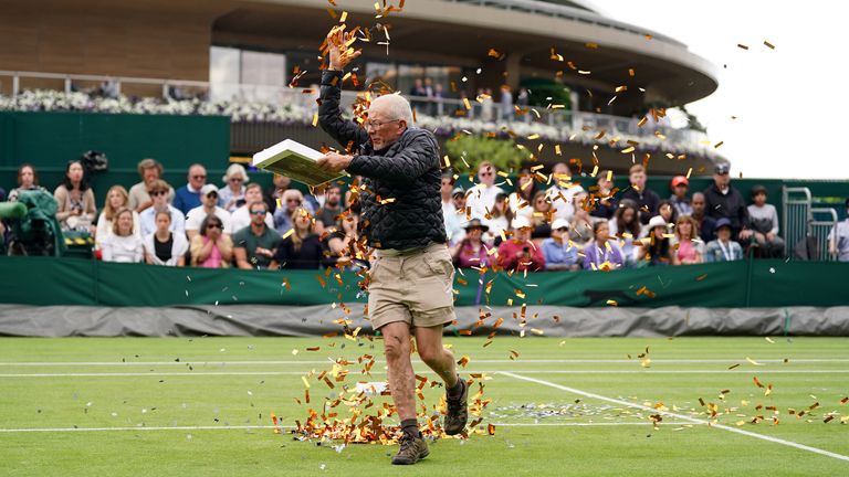 A protester on court 18 throwing confetti on to the grass during Katie Boulter’s first-round match against Daria Saville on day three of the 2023 Wimbledon Championships at the All England Lawn Tennis and Croquet Club in Wimbledon. Picture date: Wednesday July 5, 2023.