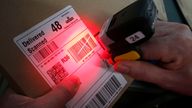 An employee at Royal Mail&#39;s Glasgow Mail Centre uses a finger scanner to help a customer track delivery of a parcel, as the centre handles millions of items during the Christmas rush on its busiest day of the year.
Read less