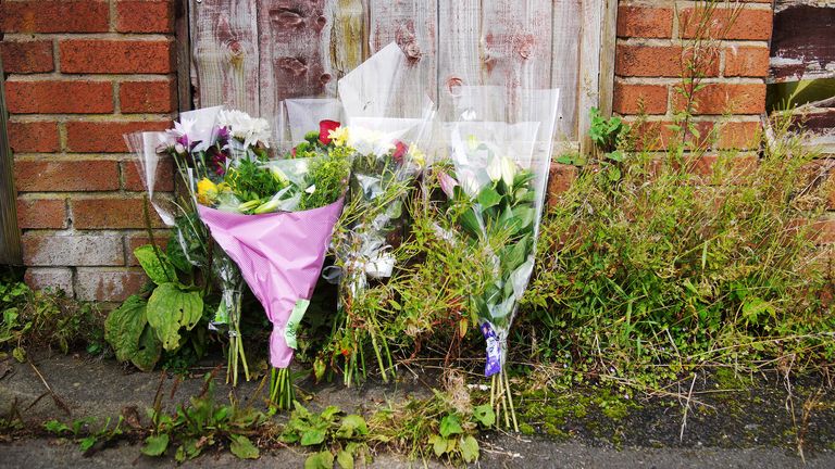 Flowers outside a property on Ainsworth Road in Radcliffe, Bury, where Greater Manchester Police said officers were called to at around 10.30am on Tuesday to reports of a burglary, with a white labradoodle dog being taken. The officers found Donald "Prentice" Patience, 45, dead at the property. Three men were arrested on suspicion of murder, and two, aged 27 and 41, have since been released on bail. Police said a 39-year-old man remains in police custody. PA Photo. Picture date: Friday August 25, 2023. See PA story POLICE Labradoodle. Photo credit should read: Peter Byrne/PA Wire 