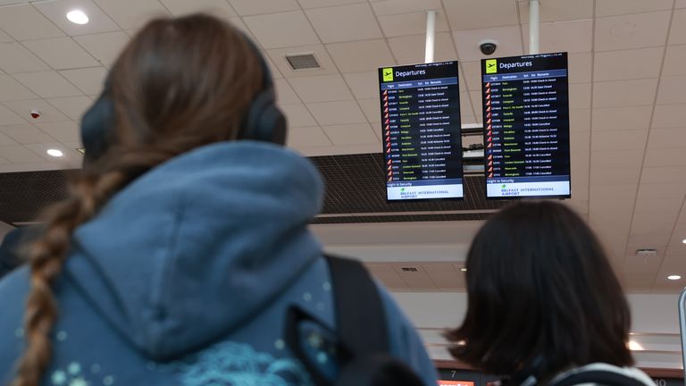 Passengers look at departure boards at Belfast International Airport, as flights to the UK and Ireland have been cancelled as a result of air traffic control issues in the UK. Picture date: Monday August 28, 2023.