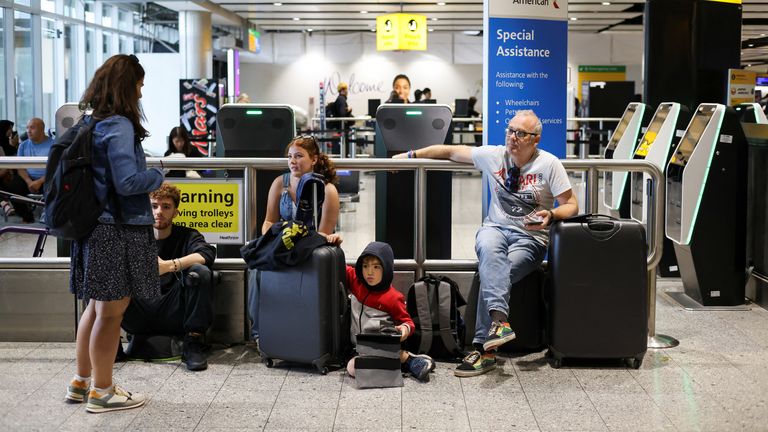 A family waits as their flight delays as Britain&#39;s National Air Traffic Service (NATS) restricts UK air traffic due to a technical issue causing delays, in London