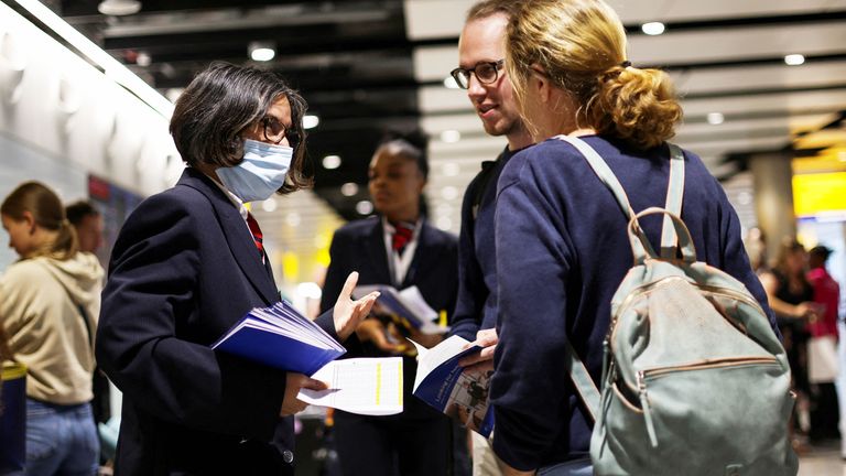 A British Airways staff member speaks to passengers at Heathrow Airport, as Britain&#39;s National Air Traffic Service (NATS) restricts UK air traffic due to a technical issue causing delays, in London, Britain, August 28, 2023. REUTERS/Hollie Adams