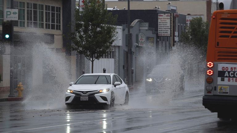 A vehicle splashes through puddles along a street starting to flood in the Van Nuys section of Los Angeles as a tropical storm moves into the area on Sunday, Aug. 20, 2023. Tropical Storm Hilary is no longer a hurricane but it&#39;s still packing what forecasters call "life-threatening" rain as it speeds up Mexico&#39;s Baja coast toward Southern California. (AP Photo/Richard Vogel)