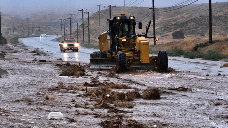 A plough clears debris along a flooded Sierra Highway in Palmdale, California yesterday as Tropical Storm Hilary moves through the area. Credit: AP