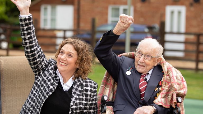 Handout photo of Second World War veteran Captain Tom Moore with his daughter Hannah, as they wave to a Battle of Britain Memorial Flight flypast of a Spitfire and a Hurricane passing over his home as he celebrates his 100th birthday.